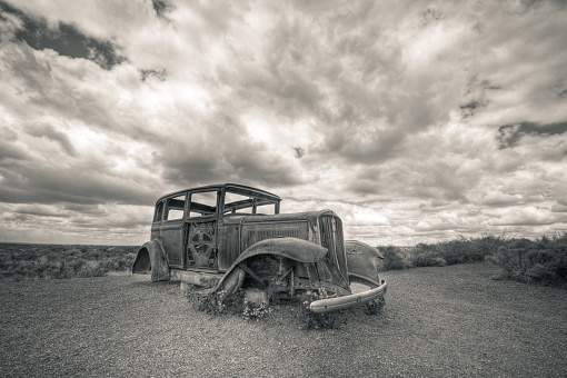 Car Wreck in USA (Route 66). The photo was taken with the HDR technique which combines photos taken at different exposure and blended together. The photo was then converted to black and white and toned differently for highlight and shadows. A vignetting was added to balance the composition.