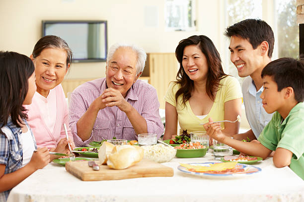 asiatique famille partage repas à domicile - asian meal photos et images de collection