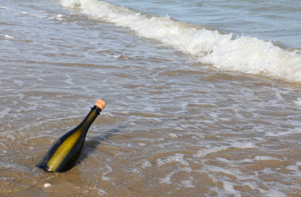 Green glass bottle with a secret message inside on the beach