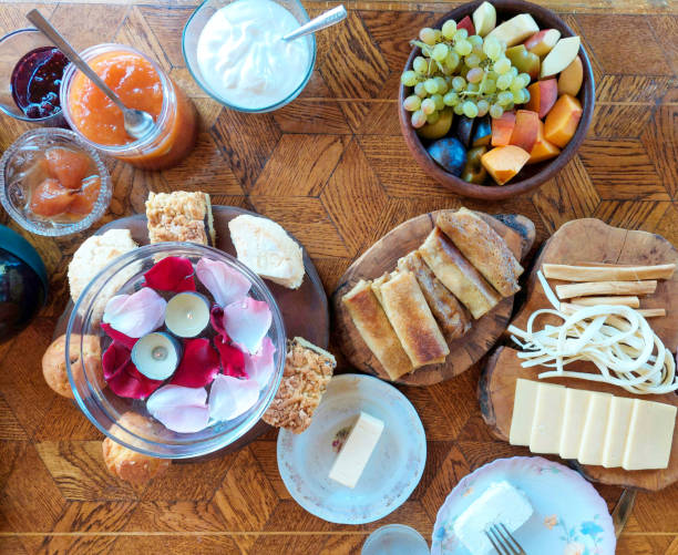 istock A prepared table for a romantic breakfast for two. Small candles and rose petals float in a vade in a glass bowl. Ladies food pancakes and fruits. 1439220261