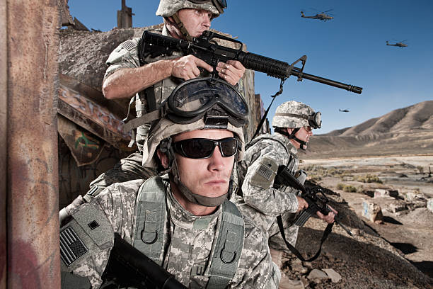 Soldiers Provide Cover in the Desert A group of U.S. Army soldiers take a defensive position in the desert, ready for any trouble that comes their way. afghanistan army stock pictures, royalty-free photos & images