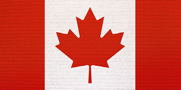 Flag of Canada painted on worn out wooden texture background.