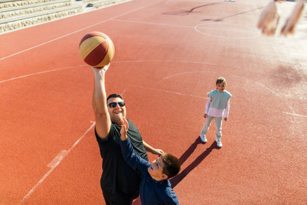 istock Father playing basketball with his children 1439220778