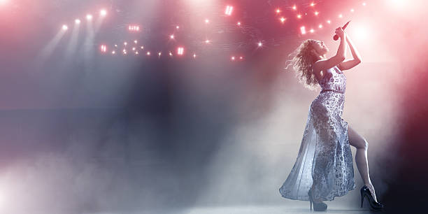 istock A female singer holds a microphone on a huge stage. 143922111