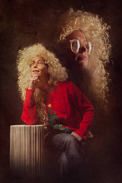 Emulated Vintage Christmas Portrait Photograph A woman from the 1980s with glasses, HUGE permed blonde hair, and a classy Christmas sweater with embroidered Christmas tree poses for a picture on a fake marble pillar column.  Intentional 80's style kitsch post processing emulation.  Vertical. high school photos stock pictures, royalty-free photos & images