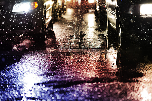 Close up of cars and other traffic light sources reflecting the rain and and snow wet streets of Stockholm, Sweden, during the early stages of a snow storm.