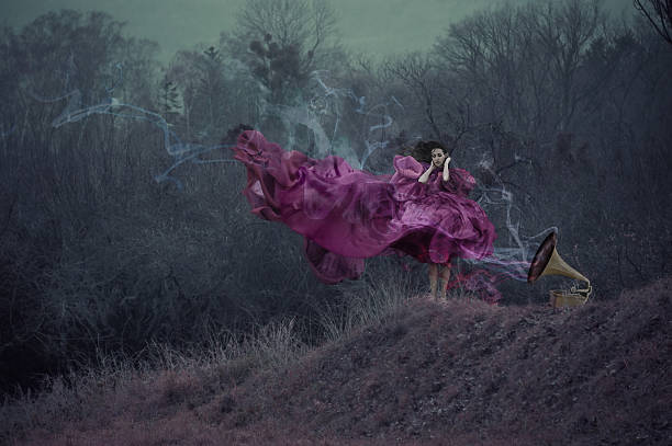 Shaman female holding hand green smoke bomb on  tree trunk in sping day