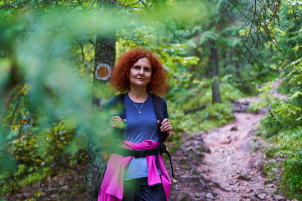 istock Woman hiker with backpack in the forest 1439224421