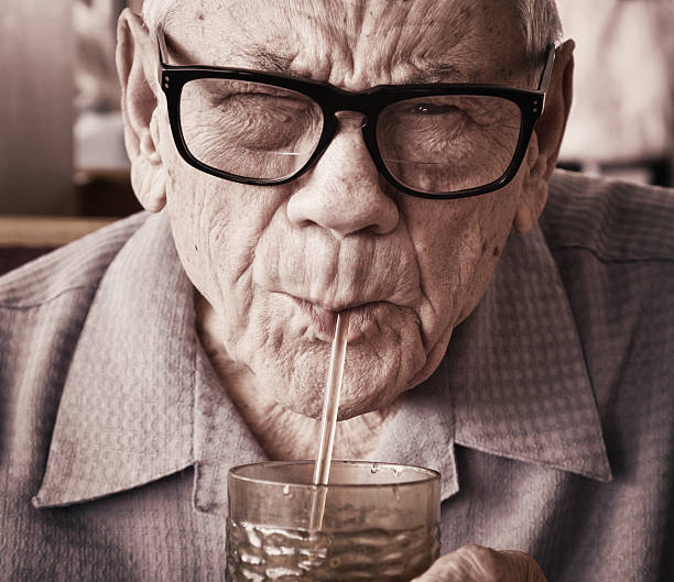 istock Senior Man Drinking Water Through Straw 143922519