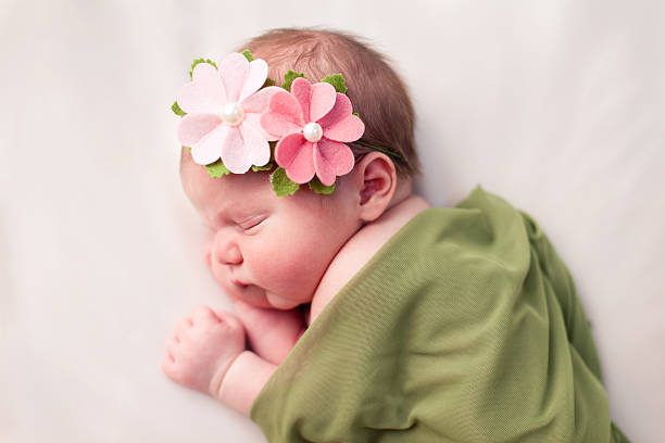 新生児の女の子心地よく包み、ソフトな毛布、緑色 - wearing flowers ストックフォトと画像