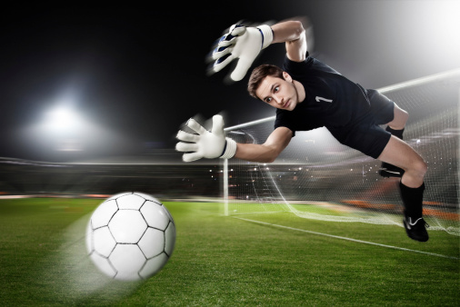 soccer goalkeeper catching  ball in the air