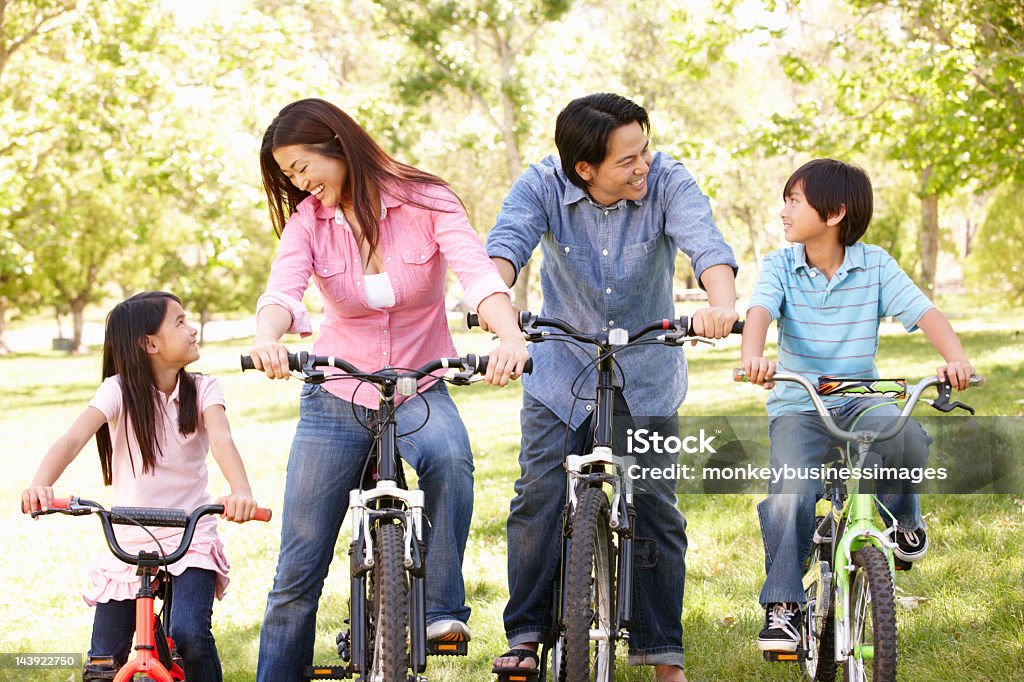 Familia asiática montar bicicletas en el parque - Foto de stock de 30-39 años libre de derechos