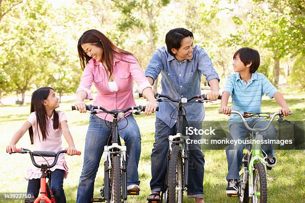 Familia Asiática Montar Bicicletas En El Parque Foto de stock y más banco de imágenes de 30-39 años - 30-39 años, 6-7 años, 8-9 años