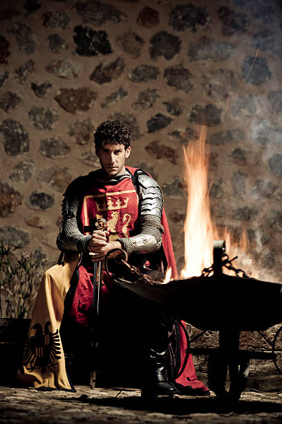 Medieval Knight sitting in the darkness closed to fire