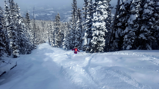 Expert mature woman skier in deep powder, Big Sky ski resort, Montana.