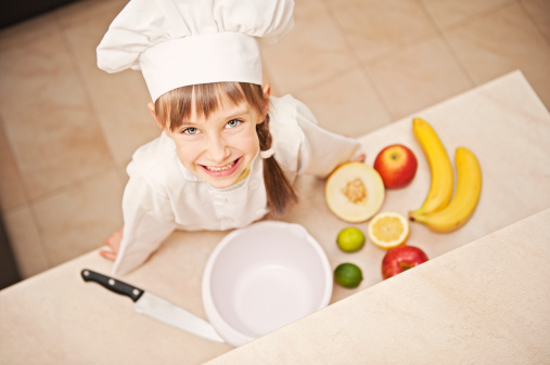 Little girl chef about to make a fruit salad.