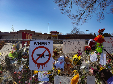 Boulder, Colorado, USA-March 29, 2021:Spontaneous memorial decorations  and signs along fenced off site of March 22, 2021 King Soopers grocery store shooting in Boulder, Colorado killing 10.