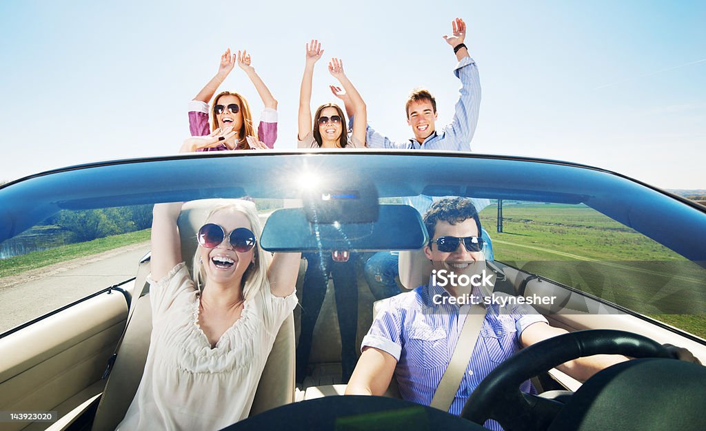 Grupo de jóvenes disfrutar de un paseo en coche descapotable. - Foto de stock de Adolescencia libre de derechos