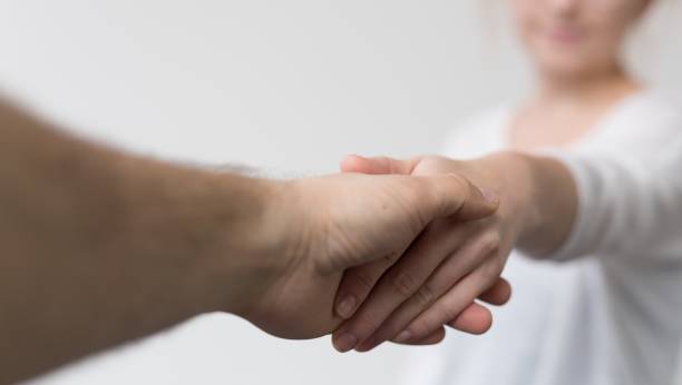 istock Closeup of people shaking hands under the lights on a blurry background 1439230257