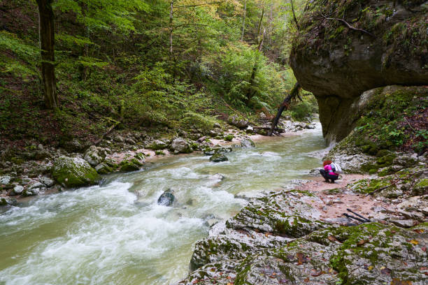 istock Woman collecting pebbles on river bank 1439231636