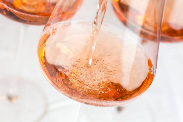 verser le vin de rose dans un verre - rosé photos et images de collection