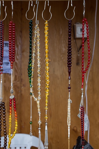 A closeup of colorful beaded necklaces against a wooden wall