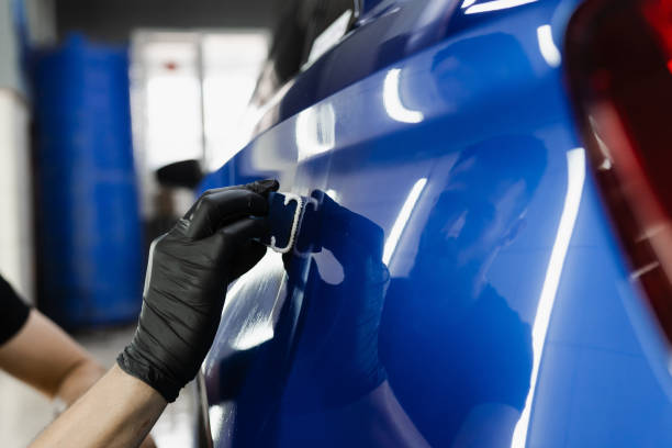 processo de aplicação de revestimento protetor cerâmico no carro da carroceria usando esponja no serviço de automóvel detalhado. o trabalhador do serviço de carro aplica revestimento cerâmico para proteger a carroceria dos arranhões. - protective varnish - fotografias e filmes do acervo