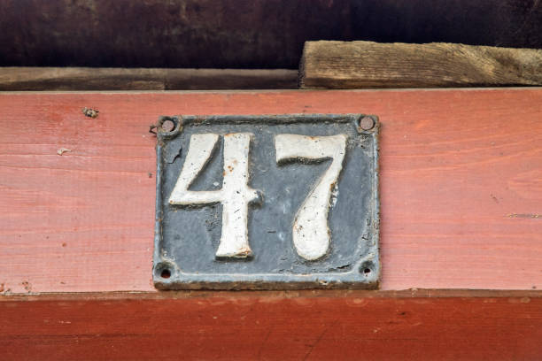 Old retro weathered cast iron plate with number 47 closeup