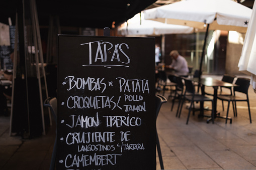 Tapas bar restaurant cafe in the historic center in Barcelona Spain. Street cafe standing banner with chalk drawing and inscription