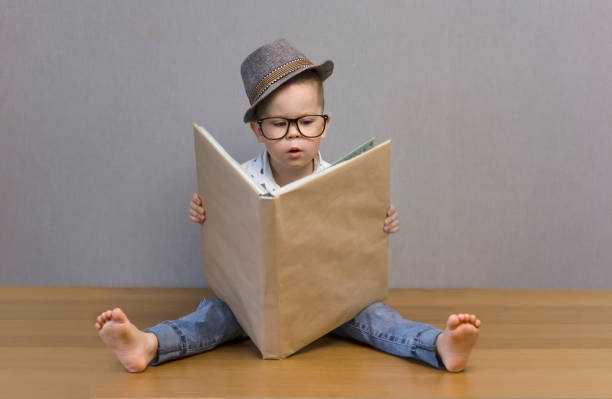 istock The kid is reading a big book very concentrated. 1439245268
