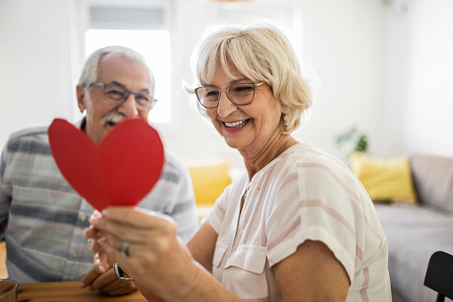 Seniors at home having fun together exchanging gifts