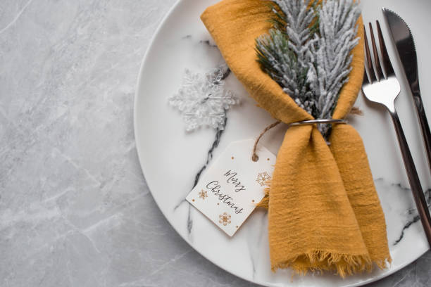 istock Table setting. A marble plate with a snowflake on a napkin, Christmas tree branches and Christmas decorations on a gray background. The concept of Merry Christmas, New Year 2023 and restaurants. 1439249829
