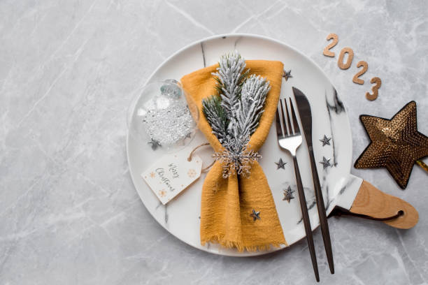 istock Table setting. A marble plate with a snowflake on a napkin, Christmas tree branches and Christmas decorations on a gray background. The concept of Merry Christmas, New Year 2023 and restaurants. 1439249843