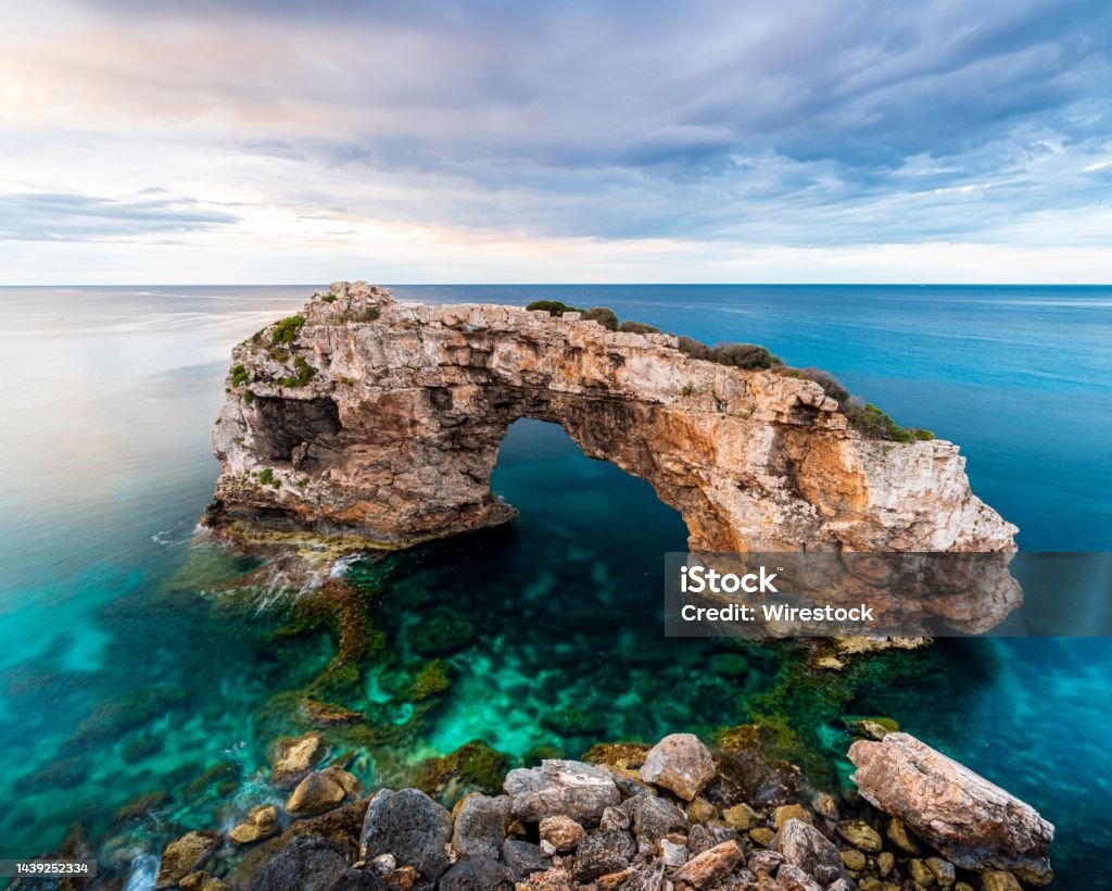 Es Pontas natural arch on the northern coast of the island of Mallorca in Spain The Es Pontas natural arch on the northern coast of the island of Mallorca in Spain Beach Stock Photo
