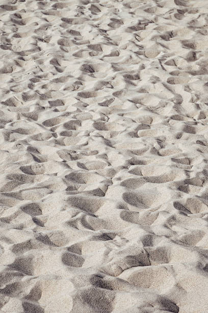 A sandy beach with footprints stock photo