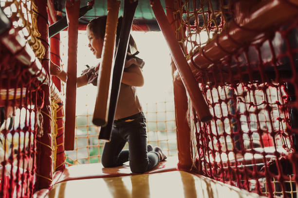 One girl, cute little girl playing in modern playground with toys and obstacles.