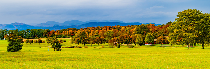 banner of Vermont farm meadows and fields in Autumn with the New York Adirondack Mountains in the distance