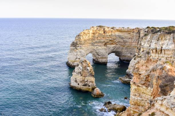 istock Large cliffs sticking out of the water during daytime 1439258618