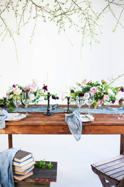 istock Bouquets of pink flowers on a table set for dinner with candles 1439261877