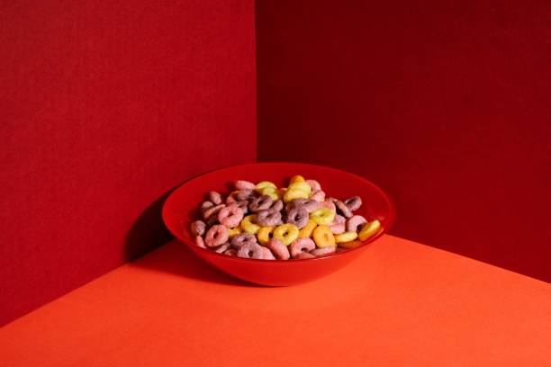 Closeup shot of colourful cereals in a red bowl on red corner background