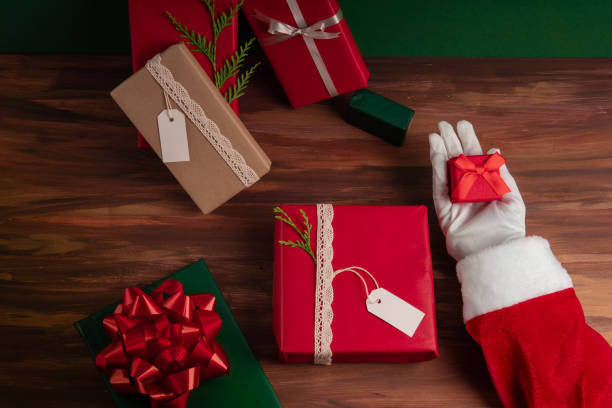 Cropped Santa Claus Hands Holding Christmas Gift stock photo