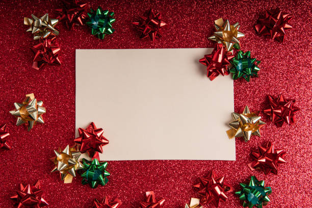 Mockup Christmas card among Christmas  ornaments over a red glitter backdrop stock photo