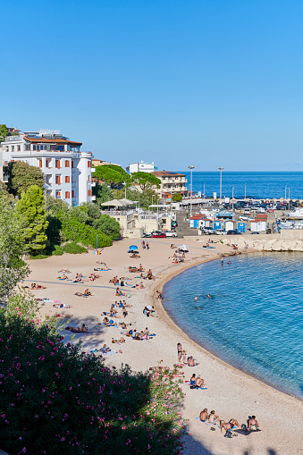 Dorgali, Italy - October 4, 2022: tourists enjoy a sunny day of October at the main beach of Cala Gonone.