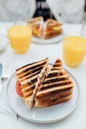 Having breakfast with healthy  vegetarian toasted sandwich with orange juice