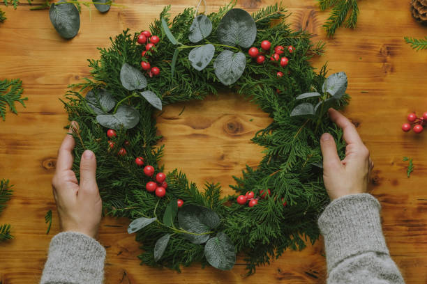 istock Hands with evergreen Christmas wreath. 1439269001