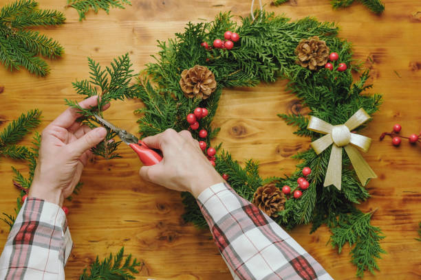 istock Hands making Christmas wreath. DIY home decor for winter holidays. 1439269006