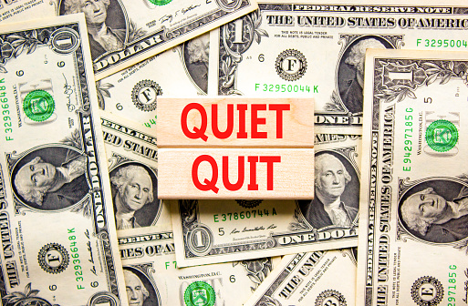 Quiet quit symbol. Concept words Quiet quit on wooden blocks. Beautiful background from dollar bills. Business and quiet quit concept. Copy space.