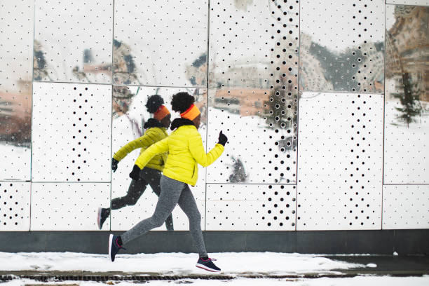 Young African woman training outdoors in bad weather