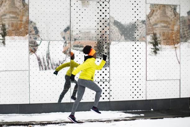 Young African woman training outdoors in bad weather