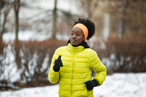 Young African woman training outdoors in bad weather